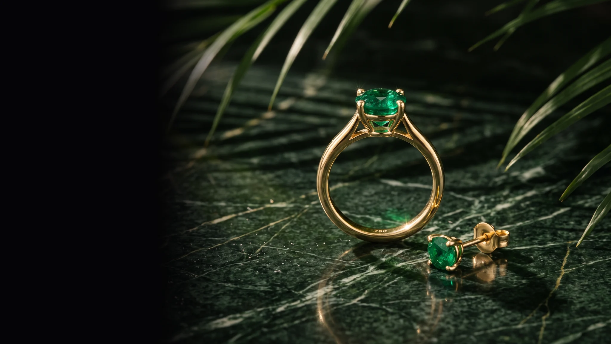 A yellow gold solitaire with an emerald and a matching emerald stud earring on dark green marble under palm fronds (illustrative, generated)